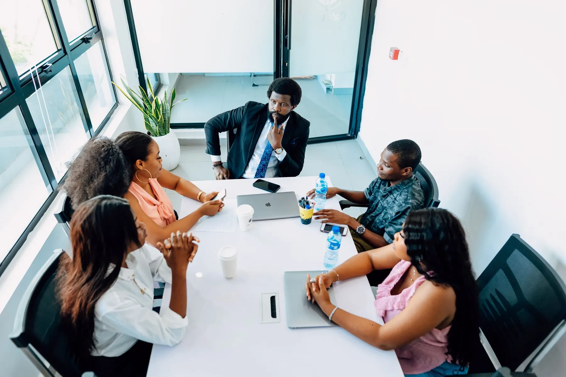 A team of consultants meeting around a table in a Lagos office